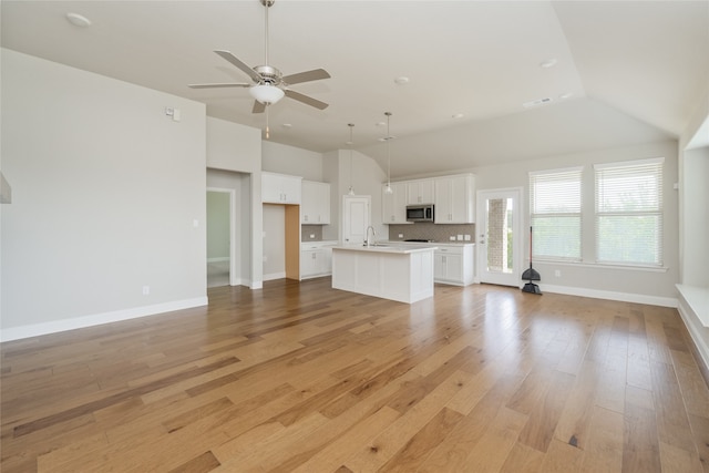 2614 Dakota Cir, Corinth, TX 76210 - unfurnished living room featuring ceiling fan, lofted ceiling, light wood finished floors, and baseboards