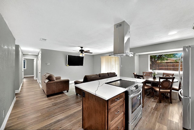 6912 Griggs St, Forest Hill, TX 76140 - kitchen with appliances with stainless steel finishes, island exhaust hood, wood finished floors, ceiling fan, and open floor plan