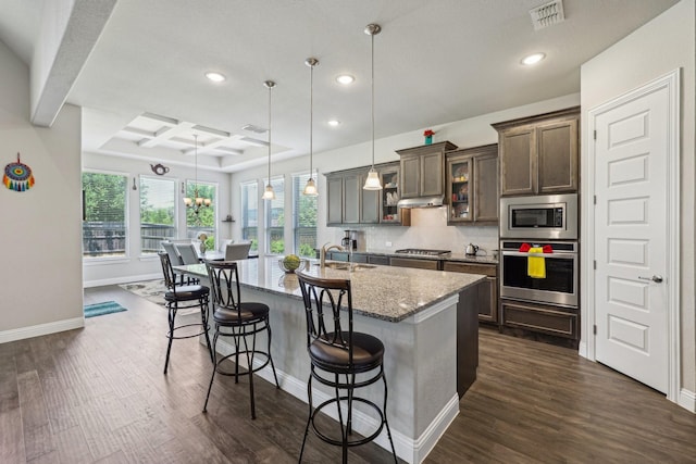 13736 Kevin Dr, Frisco, TX 75035 - kitchen featuring appliances with stainless steel finishes, recessed lighting, light stone counters, a kitchen breakfast bar, and baseboards