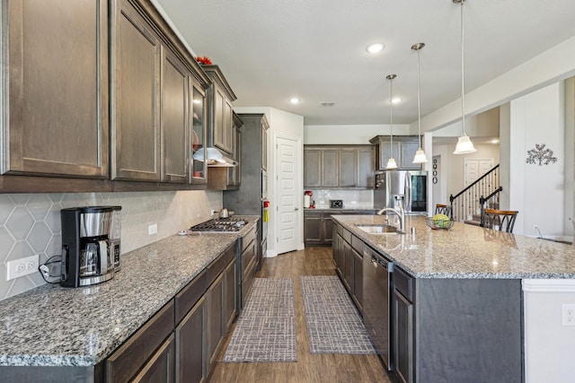 13736 Kevin Dr, Frisco, TX 75035 - kitchen featuring appliances with stainless steel finishes, a sink, dark wood finished floors, under cabinet range hood, and an island with sink