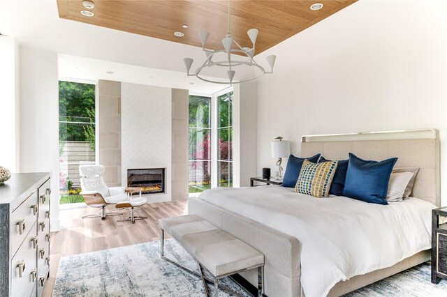 8404 Swananoah Rd, Dallas, TX 75209 - bedroom featuring wood finished floors, multiple windows, wood ceiling, a tiled fireplace, and recessed lighting
