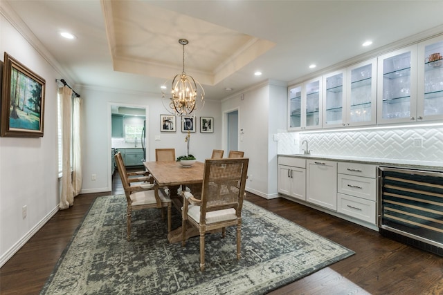 7514 Caillet St, Dallas, TX 75209 - dining room with wine cooler, crown molding, a tray ceiling, dark wood-style flooring, and a chandelier