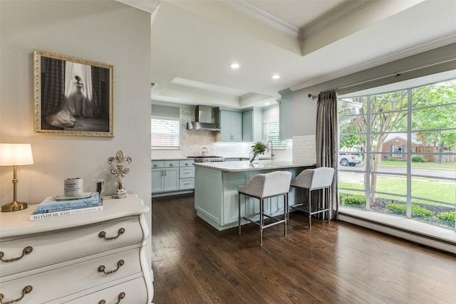 7514 Caillet St, Dallas, TX 75209 - kitchen featuring a tray ceiling, crown molding, wall chimney range hood, backsplash, and a kitchen bar