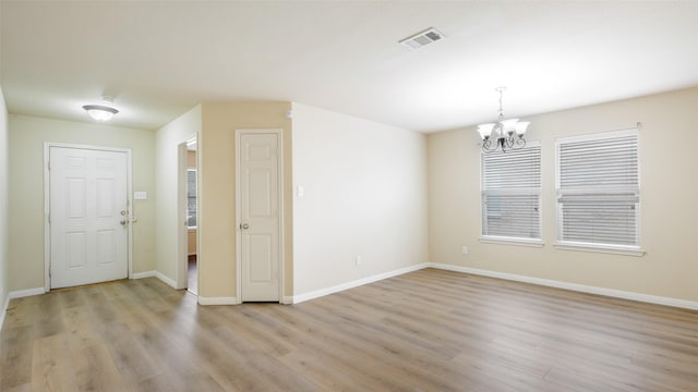 1508 Mockingbird Dr, Aubrey, TX 76227 - empty room with a chandelier, light wood-style floors, and baseboards