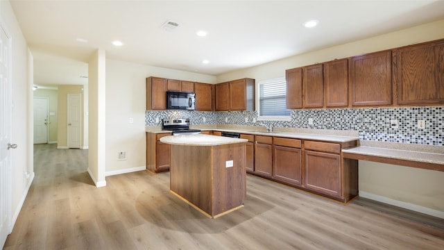 1508 Mockingbird Dr, Aubrey, TX 76227 - kitchen featuring black microwave, electric stove, a sink, light wood-type flooring, and brown cabinetry