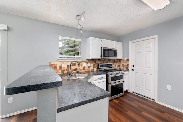 10315 Budtime Ln, Dallas, TX 75217 - kitchen with appliances with stainless steel finishes, a peninsula, a sink, white cabinetry, and tasteful backsplash