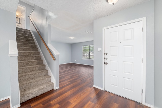 10315 Budtime Ln, Dallas, TX 75217 - foyer with stairway, dark wood-style flooring, baseboards, and a textured ceiling