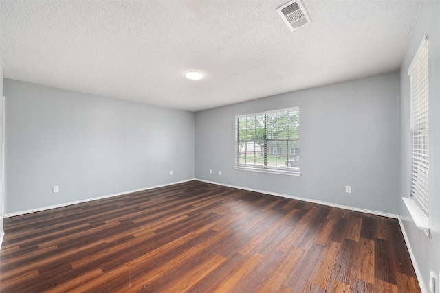 10315 Budtime Ln, Dallas, TX 75217 - unfurnished room with dark wood-type flooring, a textured ceiling, and baseboards