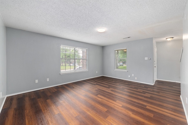 10315 Budtime Ln, Dallas, TX 75217 - spare room with dark wood-style flooring, a textured ceiling, and baseboards