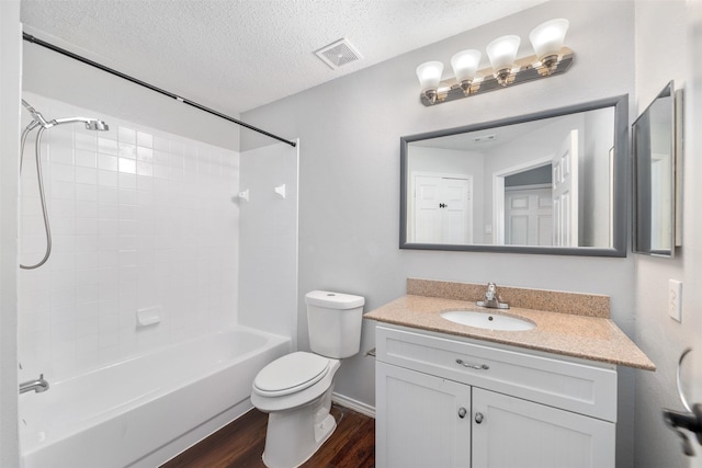 10315 Budtime Ln, Dallas, TX 75217 - full bath with wood finished floors, a textured ceiling, toilet, vanity, and shower / bathtub combination