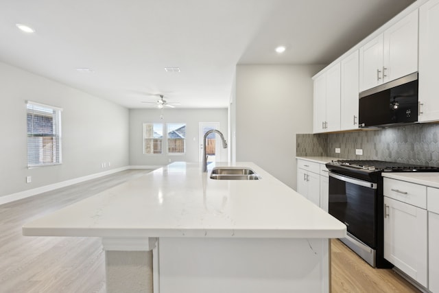 510 Willet Dr, Mckinney, TX 75069 - kitchen with stainless steel range with gas stovetop, a sink, ceiling fan, decorative backsplash, and a kitchen island with sink