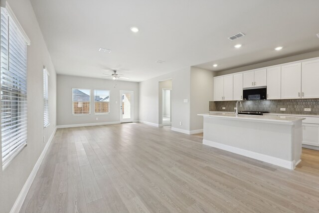 510 Willet Dr, Mckinney, TX 75069 - kitchen with black microwave, light wood finished floors, backsplash, light countertops, and recessed lighting