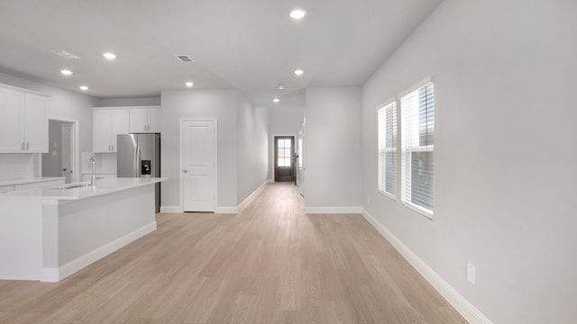 516 Willet Dr, Mckinney, TX 75069 - kitchen with stainless steel fridge with ice dispenser, light countertops, white cabinetry, recessed lighting, and light wood-style flooring