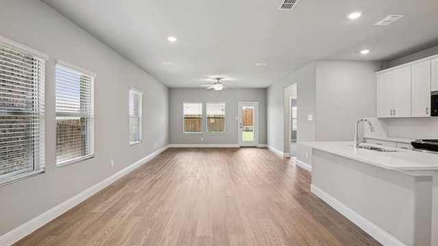 516 Willet Dr, Mckinney, TX 75069 - kitchen with light countertops, light wood-type flooring, recessed lighting, a ceiling fan, and white cabinets