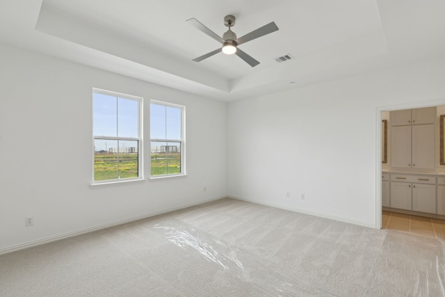 15792 Millwood Trl, Frisco, TX 75033 - empty room with a raised ceiling, light colored carpet, ceiling fan, and baseboards