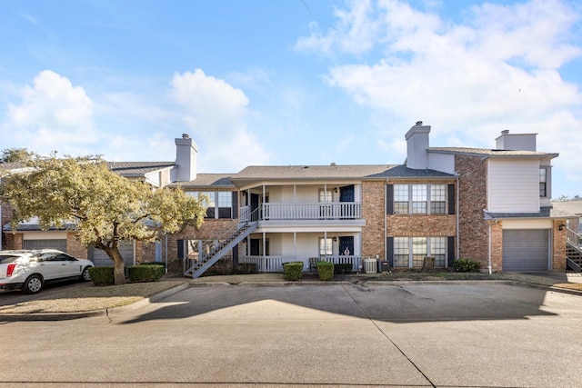 3101 Townbluff Dr Unit 1013, Plano, TX 75075 - view of front of property with a porch, a chimney, brick siding, stairway, and an attached garage
