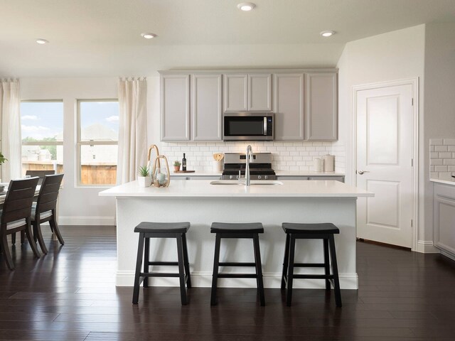 502 Stagg St, Mckinney, TX 75069 - kitchen with appliances with stainless steel finishes, light countertops, a kitchen breakfast bar, backsplash, and recessed lighting