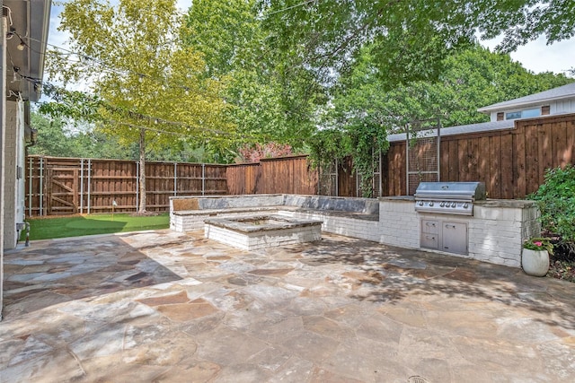 3970 Cobblestone Cir, Dallas, TX 75229 - view of patio featuring area for grilling, an outdoor kitchen, a fire pit, and a fenced backyard