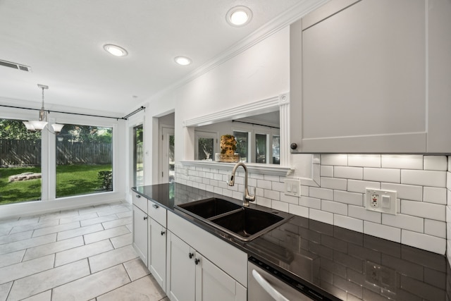 2207 Oakwood Ln, Arlington, TX 76012 - kitchen featuring a sink, dark countertops, crown molding, tasteful backsplash, and light tile patterned floors