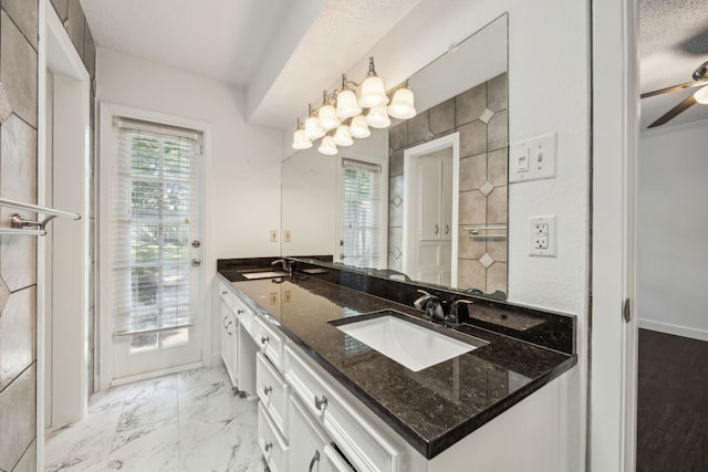 2207 Oakwood Ln, Arlington, TX 76012 - full bathroom featuring a ceiling fan, double vanity, and marble look tile flooring