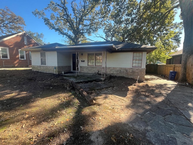 view of front of house with stone siding and fence