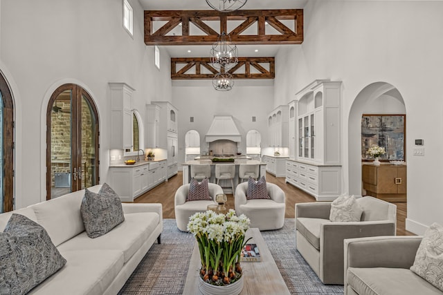 2210 Barcelona Ct, Westlake, TX 76262 - living area with a high ceiling, a chandelier, wood finished floors, and arched walkways