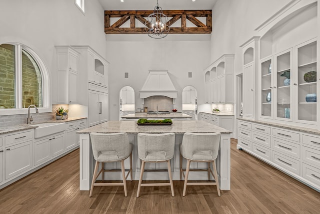 2210 Barcelona Ct, Westlake, TX 76262 - kitchen featuring a high ceiling, premium range hood, a sink, white cabinetry, and a chandelier