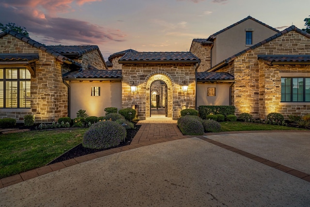 2210 Barcelona Ct, Westlake, TX 76262 - view of front of property with stone siding, stucco siding, a tile roof, and a lawn