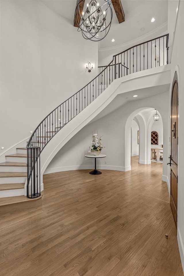 2210 Barcelona Ct, Westlake, TX 76262 - entrance foyer with a high ceiling, arched walkways, a chandelier, stairs, and beam ceiling