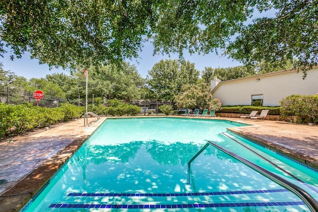 13561 Waterfall Way, Dallas, TX 75240 - community pool featuring fence, a patio area, and view of wooded area