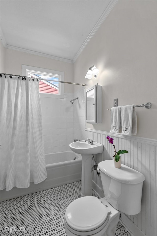bathroom featuring toilet, wainscoting, shower / tub combo, and ornamental molding