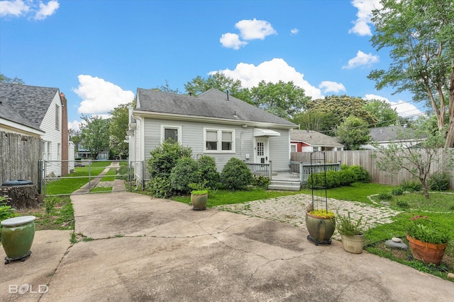 rear view of property featuring a patio, a gate, and a deck