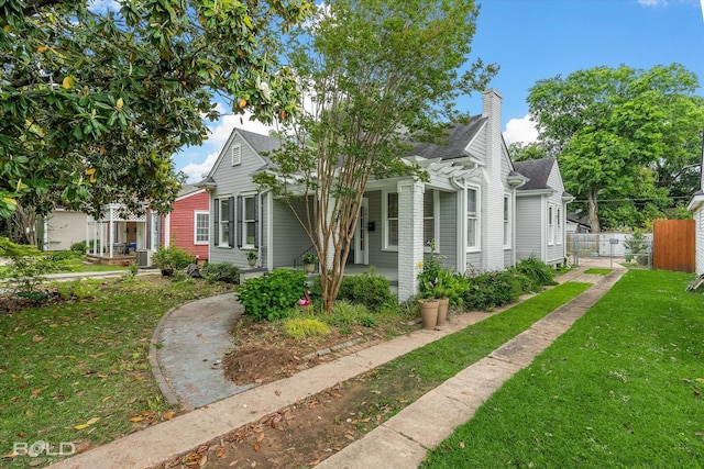 view of front of home with a chimney, a shingled roof, and covered porch