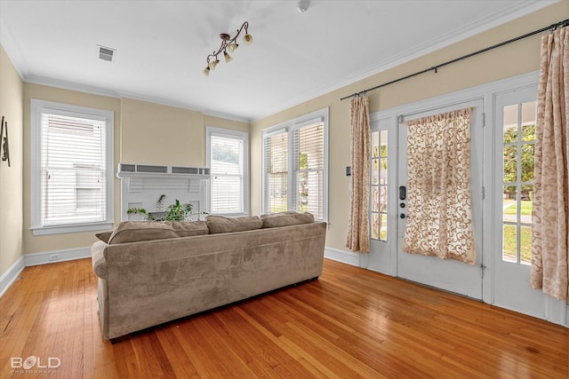 living area with light wood finished floors, baseboards, and ornamental molding