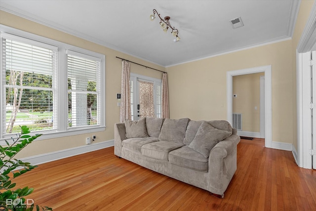 living area featuring baseboards, wood finished floors, and crown molding