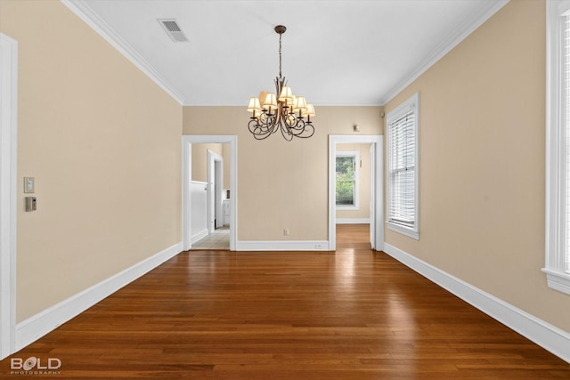 unfurnished dining area with wood finished floors, a chandelier, ornamental molding, and baseboards