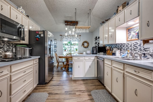 425 Headlee St, Denton, TX 76201 - kitchen with appliances with stainless steel finishes, a textured ceiling, a peninsula, light countertops, and backsplash