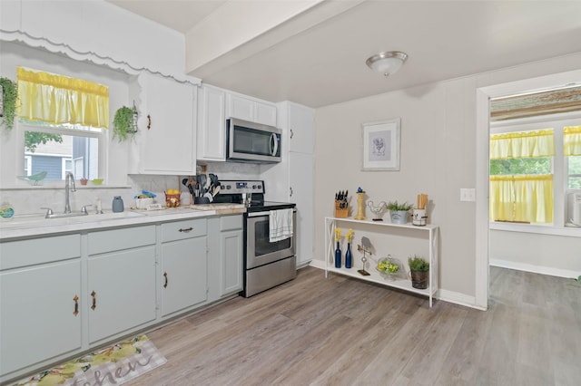211 S Wickham St, Alvord, TX 76225 - kitchen with appliances with stainless steel finishes, a sink, light countertops, tasteful backsplash, and light wood finished floors