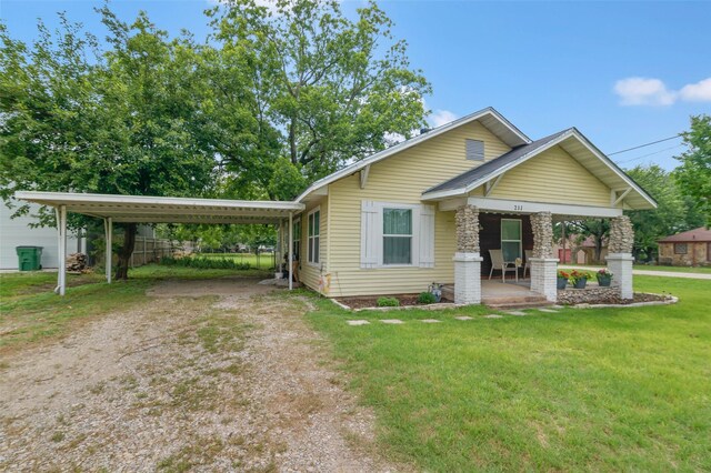 211 S Wickham St, Alvord, TX 76225 - view of front of house with a porch, dirt driveway, a front yard, and a carport