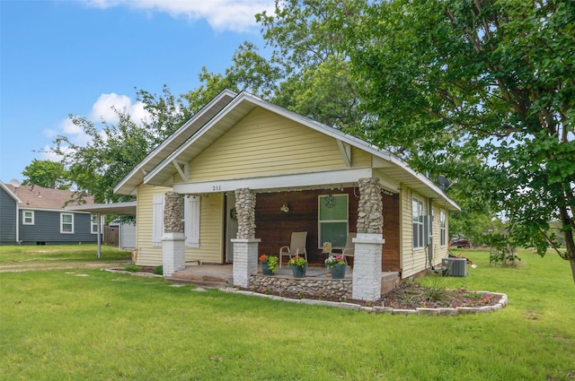 211 S Wickham St, Alvord, TX 76225 - view of front facade featuring a porch, a front yard, central AC unit, and an attached carport