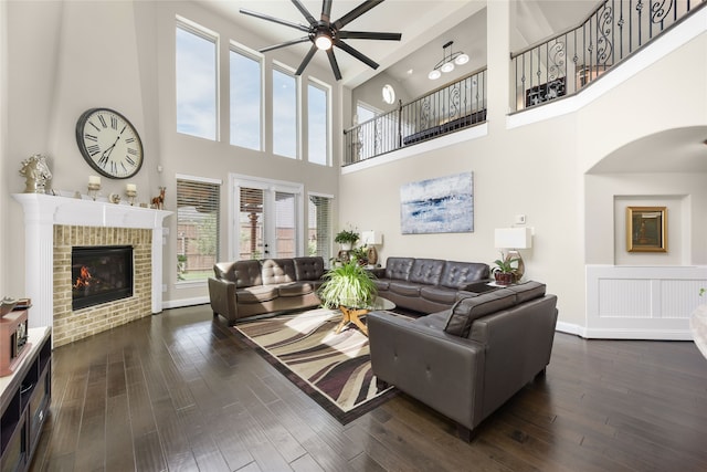 215 Dominion Dr, Wylie, TX 75098 - living room featuring ceiling fan, a high ceiling, dark wood-style floors, a fireplace, and arched walkways