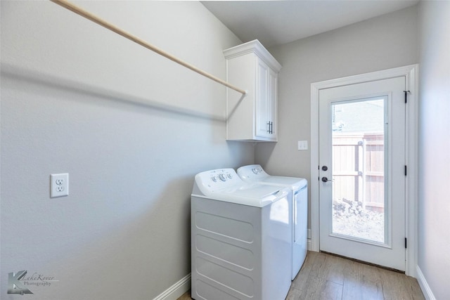6709 Tradition Dr, Abilene, TX 79606 - laundry area with cabinet space, washer and clothes dryer, light wood-type flooring, and baseboards
