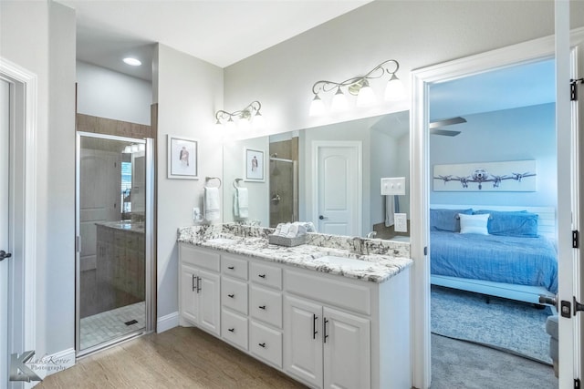 6709 Tradition Dr, Abilene, TX 79606 - ensuite bathroom featuring a shower stall, double vanity, wood finished floors, and baseboards