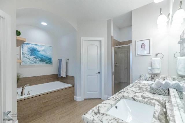 6709 Tradition Dr, Abilene, TX 79606 - full bath featuring a shower stall, a garden tub, double vanity, wood finished floors, and a chandelier