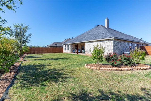 6709 Tradition Dr, Abilene, TX 79606 - back of house with a chimney, brick siding, and a shingled roof