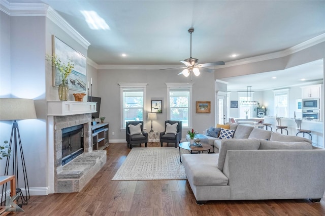 6709 Tradition Dr, Abilene, TX 79606 - living room with a fireplace, wood finished floors, a ceiling fan, recessed lighting, and ornamental molding