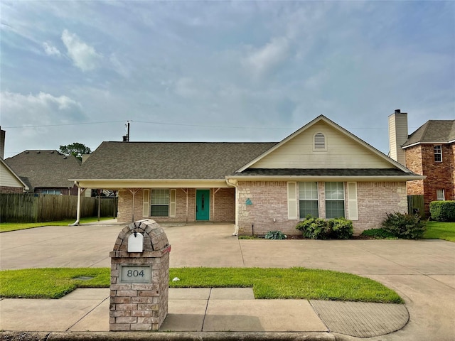 804 Austin Acre, Sulphur Springs, TX 75482 - view of front of house with fence, a shingled roof, curved driveway, and brick siding