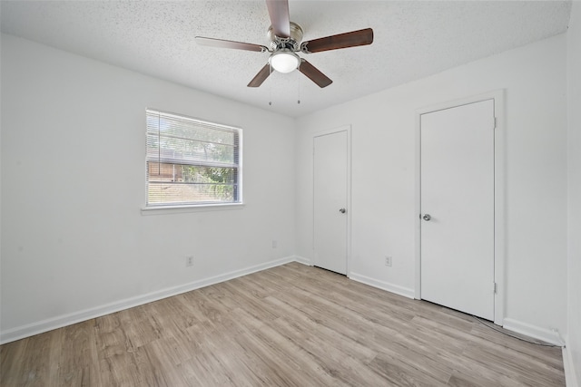 629 Chambers St, Denton, TX 76205 - unfurnished bedroom featuring light wood finished floors, a textured ceiling, baseboards, and a ceiling fan