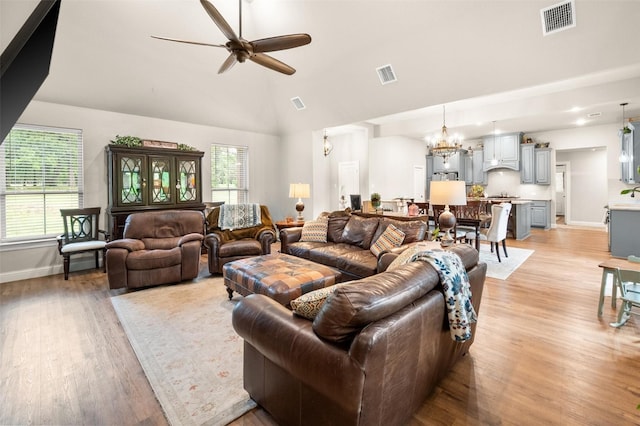 422 Sundance, Corsicana, TX 75109 - living room featuring ceiling fan, healthy amount of natural light, light wood finished floors, high vaulted ceiling, and a chandelier