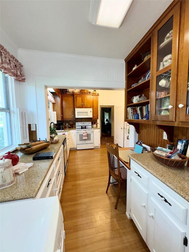 500 S Ross Ave, Mexia, TX 76667 - kitchen with white appliances, light wood-type flooring, open shelves, brown cabinetry, and glass insert cabinets